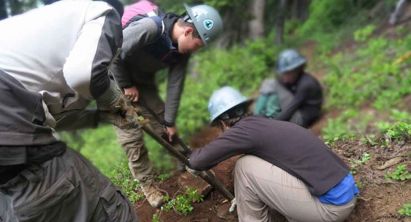 outward bound students use gardening tools during a service project